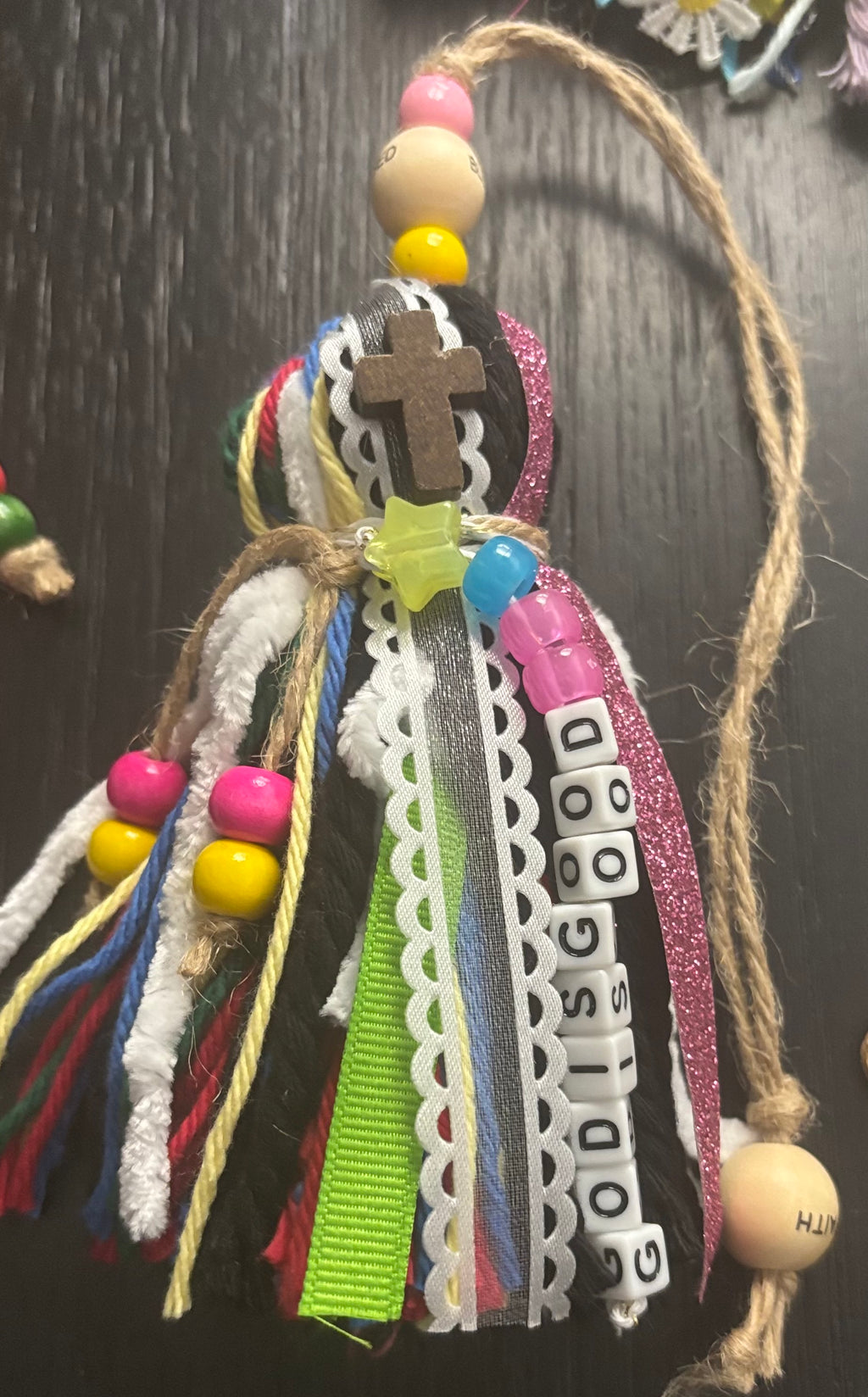 Decorative bookmark with colorful beads and ribbons on a dark background
