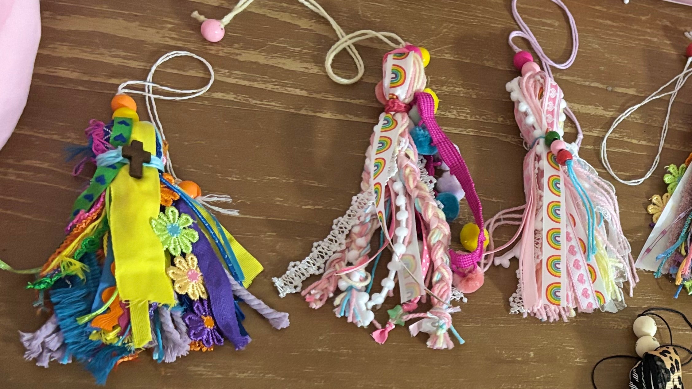 Colorful tassels and decorative ribbons on a wooden surface
