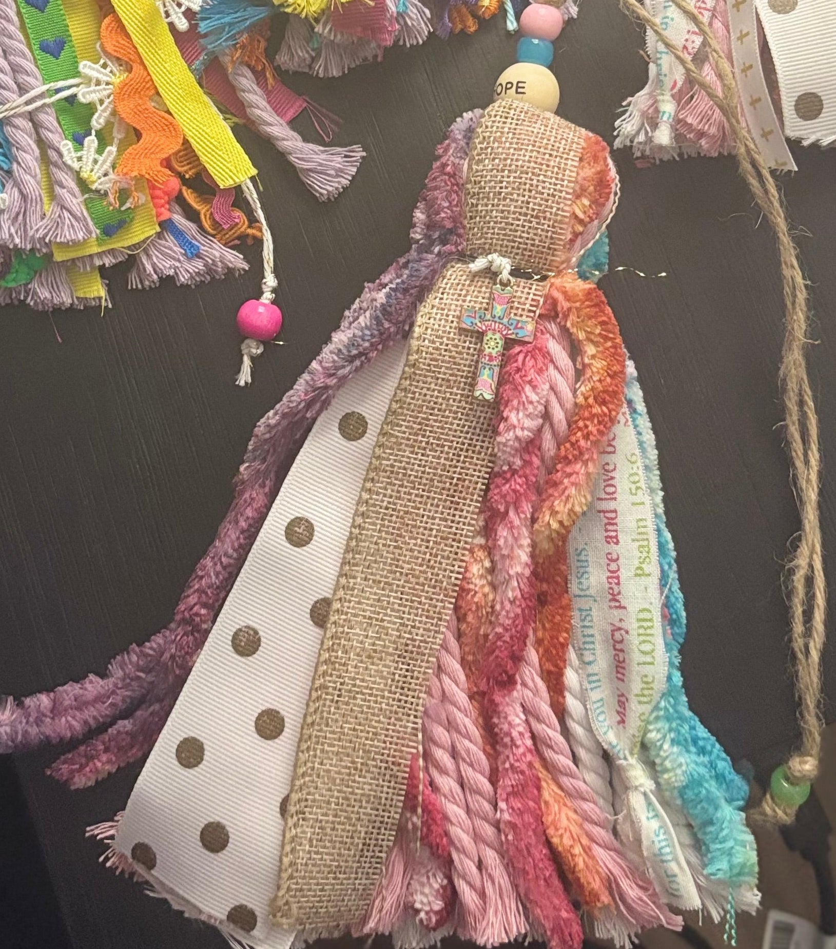 Colorful decorative hanging items with ribbons and tassels on a dark background