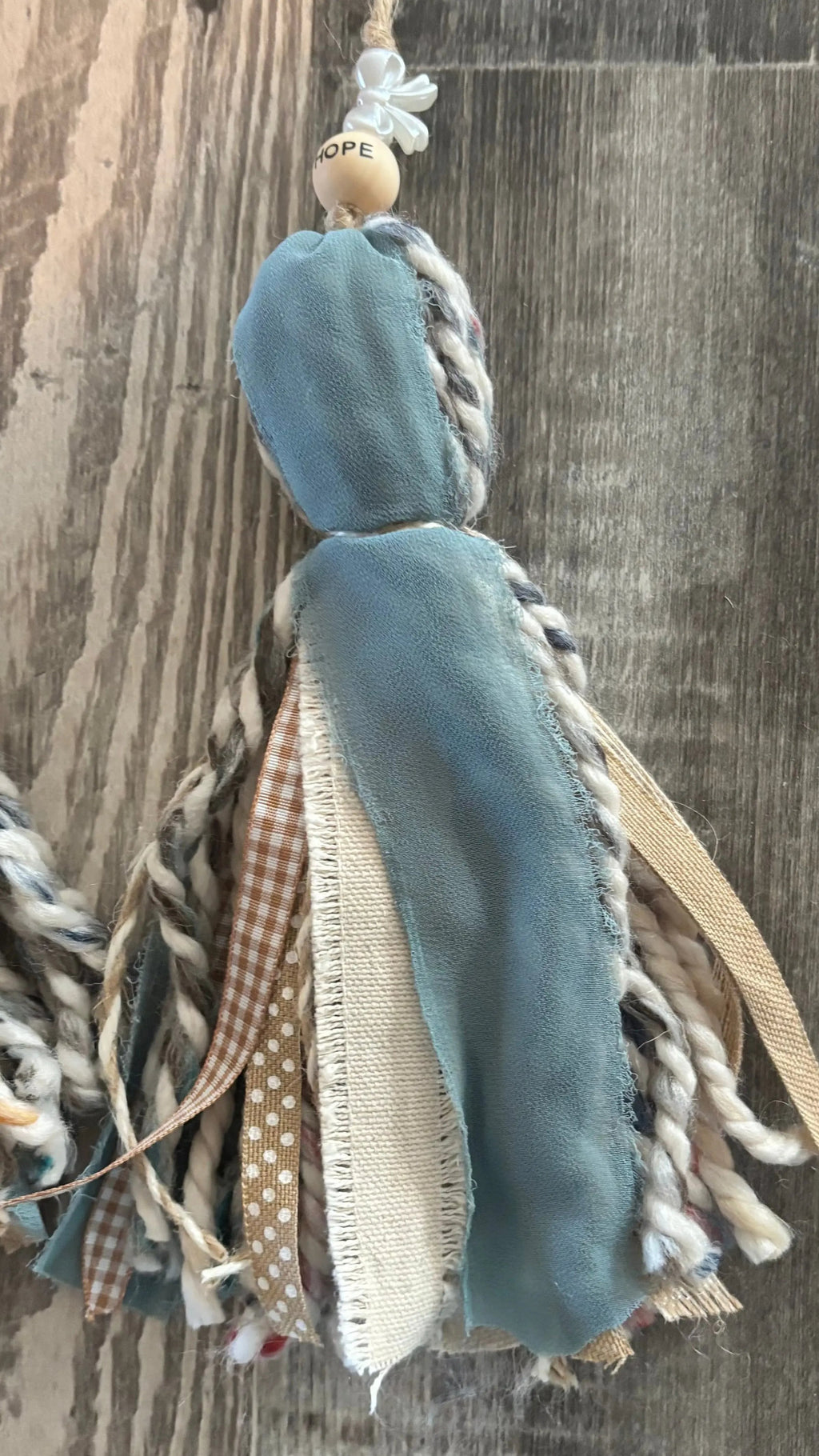 Decorative tassel with braided elements on a wooden surface