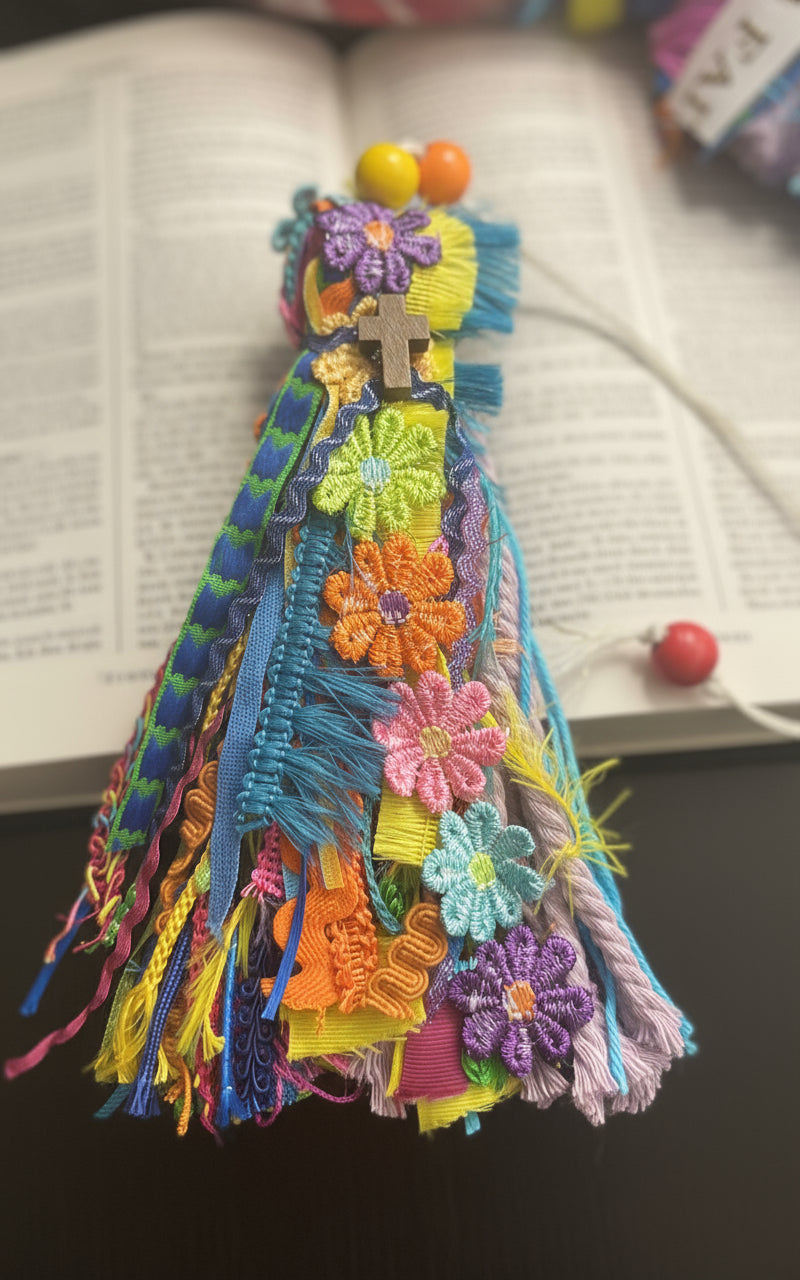 Colorful embroidered fabric bookmark with floral patterns on a dark background