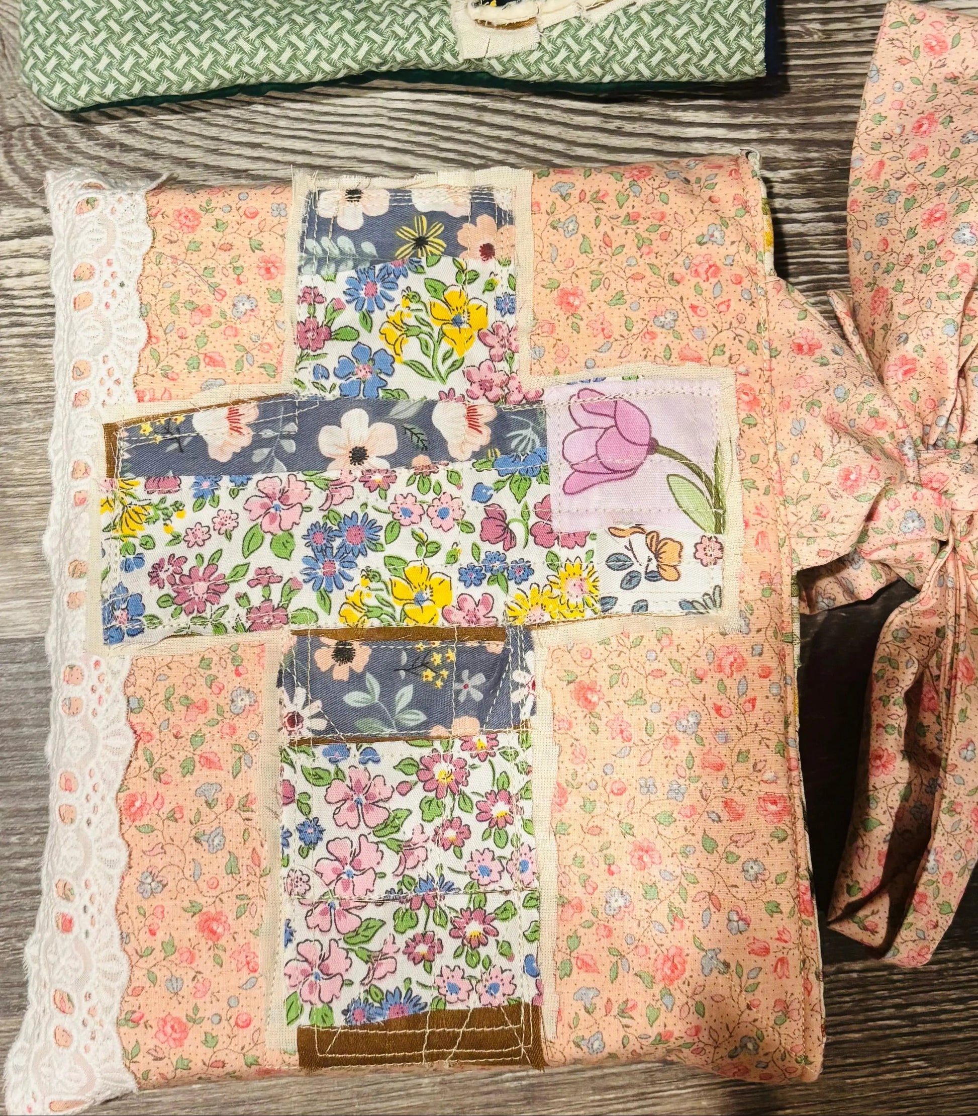 Patchwork quilted bible or book sleeves with floral patterns on a wooden surface